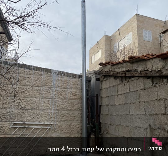עמוד מתכת בין קירות אבן ובטון